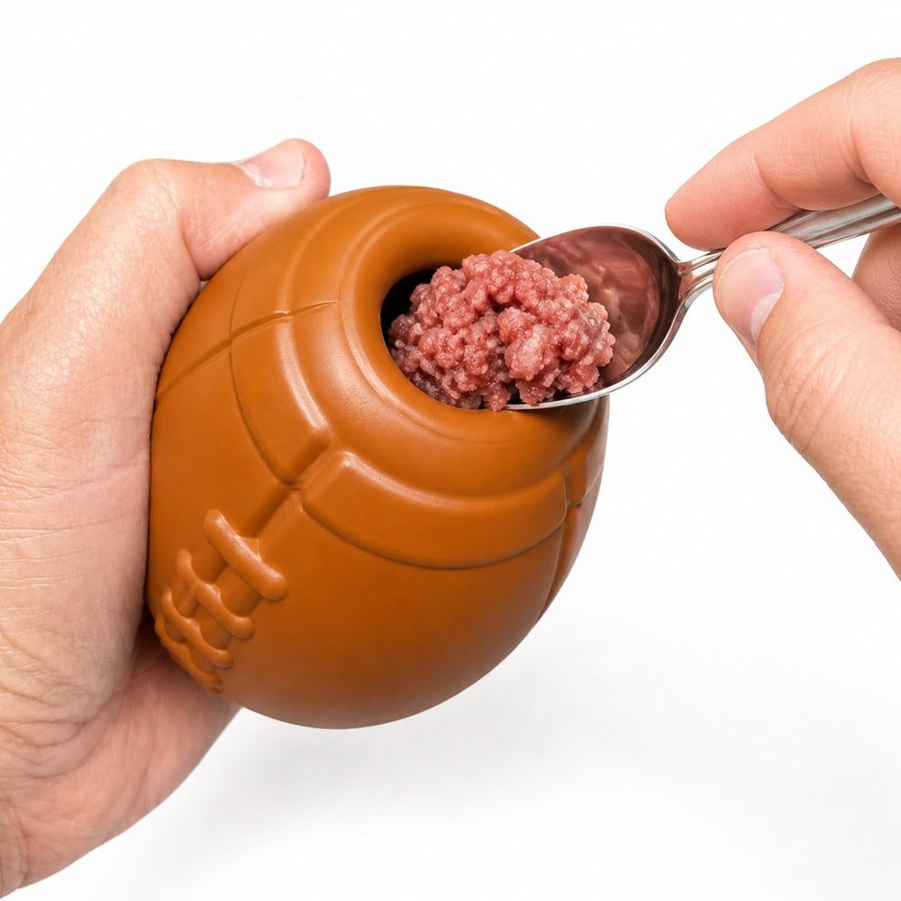 Football Treat Toy — Brown football shown with a filling; food is not included.